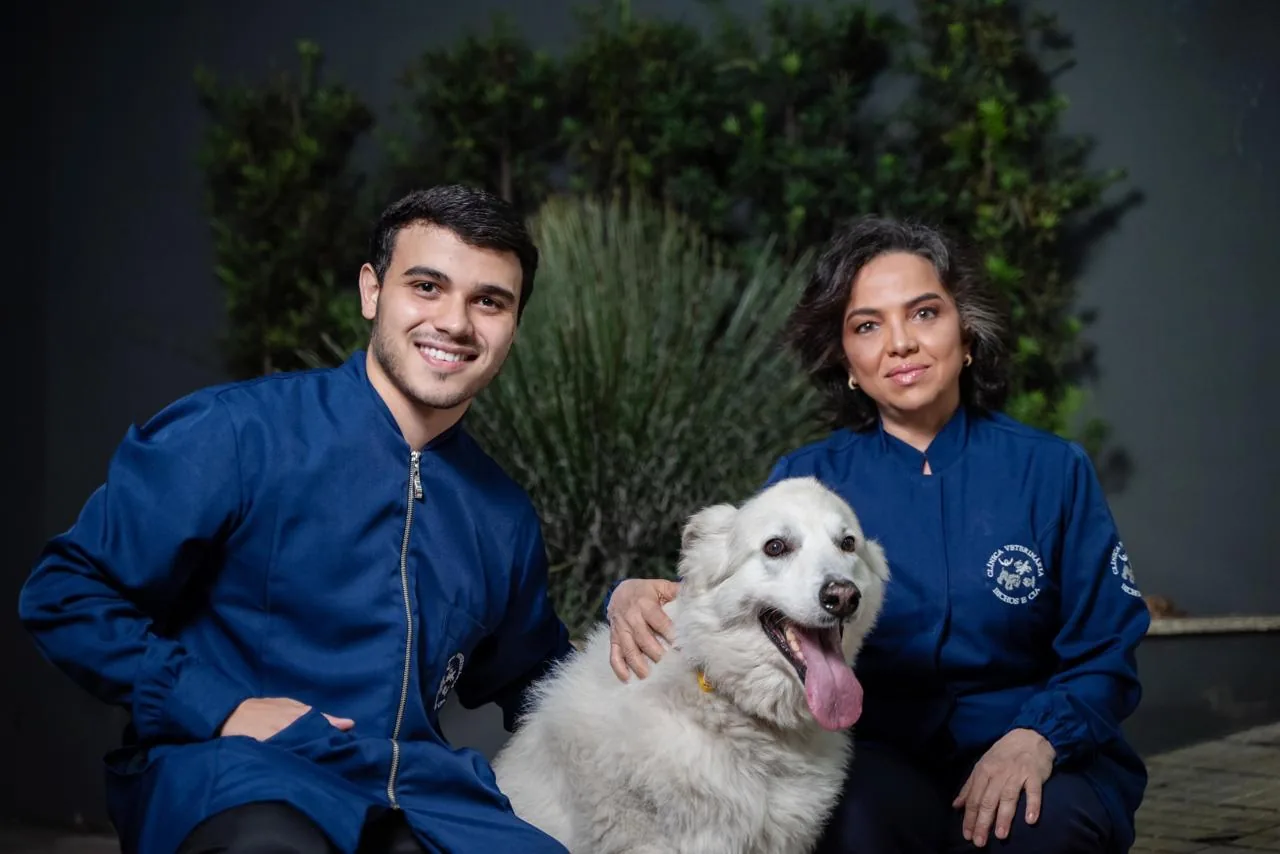 Dra. Denise Rinaldi Colli e Angelo Colli Henriques com uma cachorra branca na Bichos & Cia